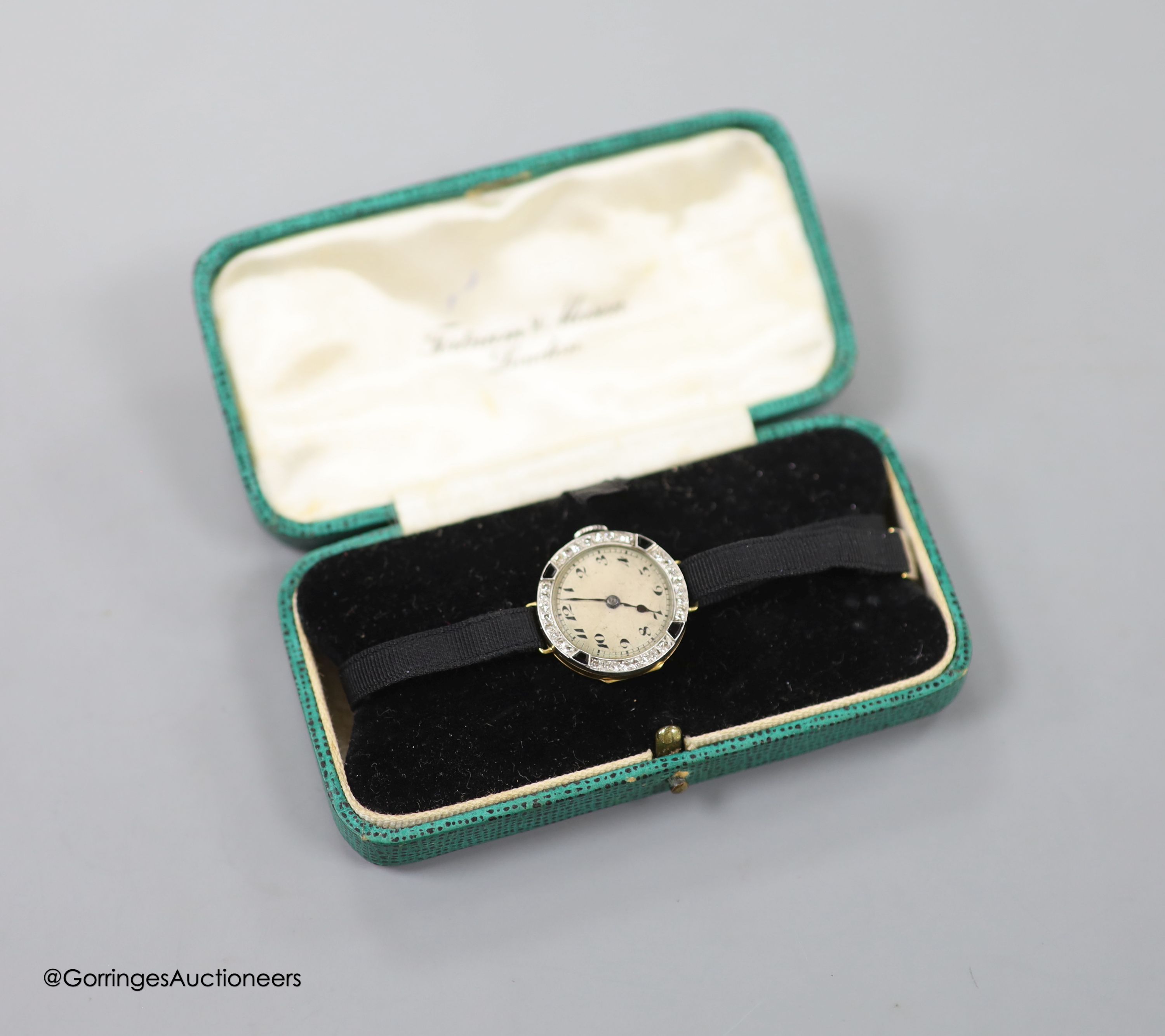 A lady's early 20th century 18ct gold, black onyx and diamond set cocktail watch, case diameter 21mm, on a fabric strap, gross weight 11.3 grams.